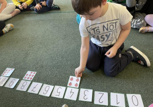 dzieci dopasowują ilość biedronek do znaku graficznego liczby